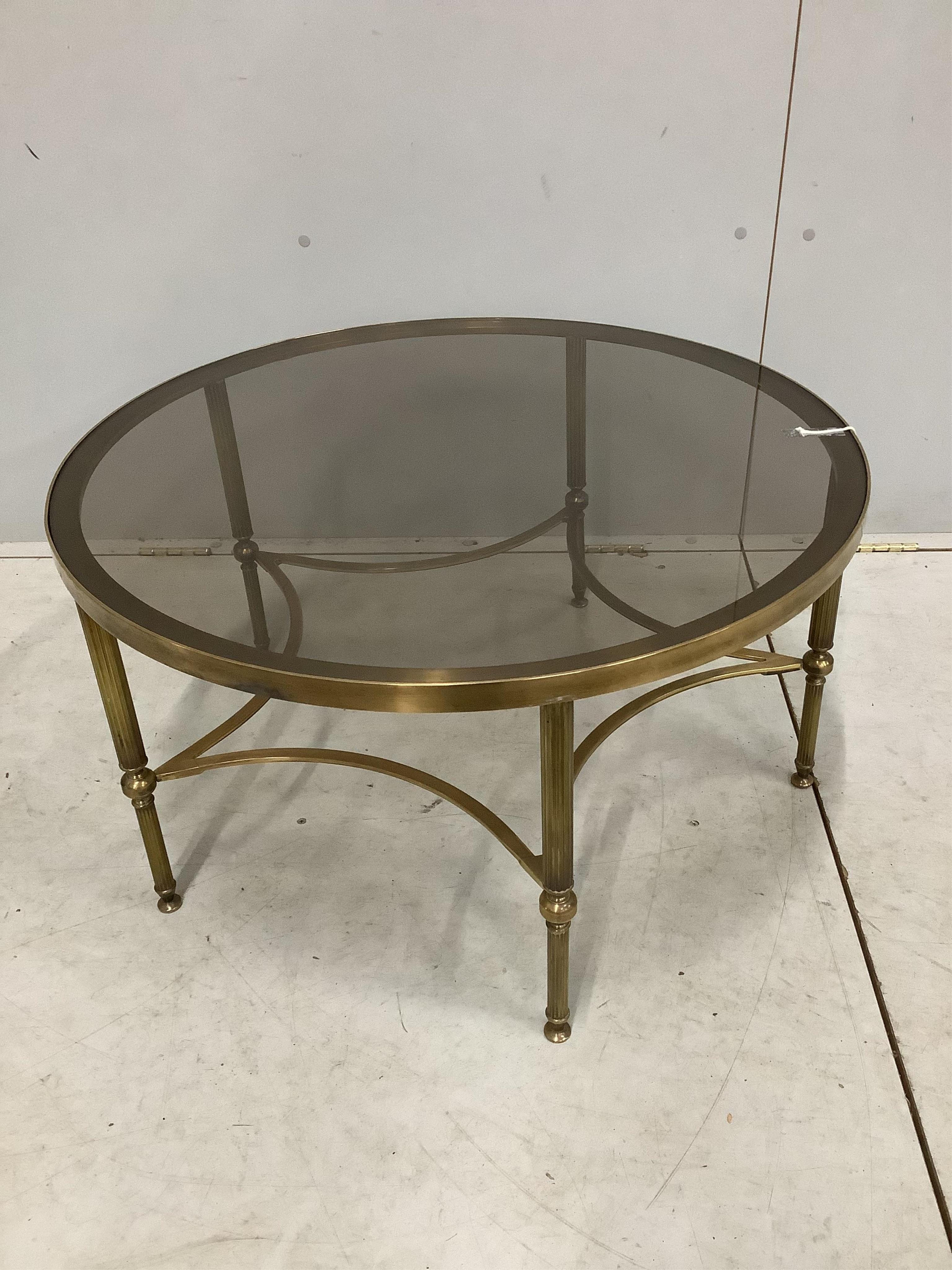 A Maison Jansen style circular brass glass top coffee table. Diameter 77cm, height 41cm, Condition - good